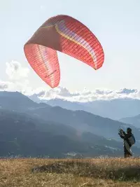 Parapentiste se préparant au décollage face aux montagnes aux Arcs