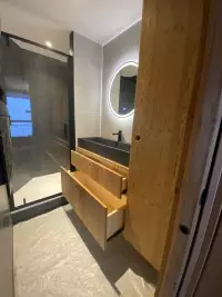 Meuble vasque en bois face à une douche vitrée