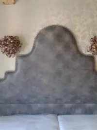 Tête de lit capitonnée grise dans une chambre