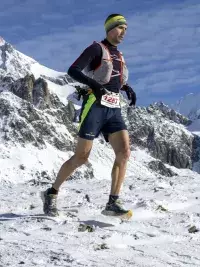 Coureur participant au Trail du Petit Saint-Bernard dans un paysage de haute montagne enneigé