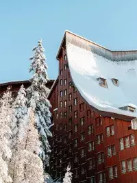 Bâtiment à l’architecture caractéristique des Arcs avec toiture couverte de neige