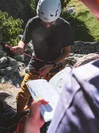 Lecture d’un topo d’escalade pour préparer une voie en montagne aux Arcs