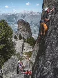 Grimpeur en escalade sur une voie rocheuse en montagne aux Arcs