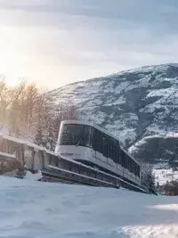 Funiculaire montant en station au cœur d’un paysage enneigé de montagne