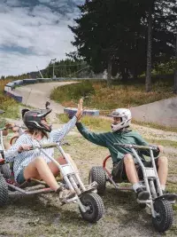 A group of friends in mountain karts giving each other a high five in Les Arcs