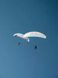 Deux parapentes dans le ciel bleu au-dessus des montagnes