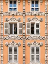 Façade ornée d’un bâtiment historique avec décors sculptés et fenêtres à volets à Bourg-Saint-Maurice.