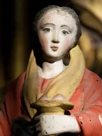 Statue religieuse polychrome représentant une femme tenant une coupe.