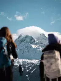 Randonneurs en raquettes observant un sommet enneigé