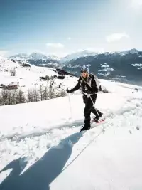 Personne en raquettes marchant dans la neige en montagne aux Arcs