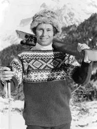 Robert Blanc portant ses skis dans un paysage enneigé.