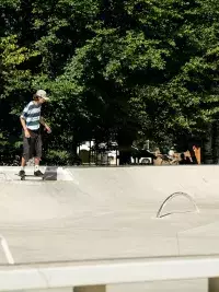 Skateur roulant dans un skatepark en plein air entouré d’arbres aux Arcs