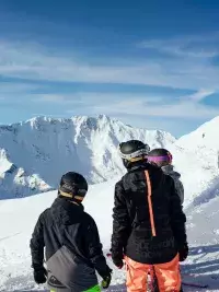 Groupe de skieurs en First Tracks face aux montagnes enneigées des Arcs