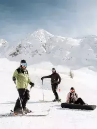 Skieurs et snowboardeuse profitant d’une journée ensoleillée sur le domaine skiable des Arcs