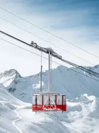 Téléphérique de l’Aiguille Rouge survolant le domaine skiable enneigé des Arcs
