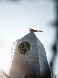 Grande tour de jeu en bois des Géants de Malgovert équipée d'un toboggan en tunnel grillagé, sous un ciel d'hiver lumineux