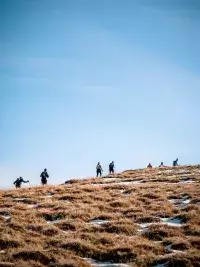 Deux trailers avancent sur un chemin de crêtes rocheux et technique en haute montagne aux Arcs, avec une vue plongeante spectaculaire sur la vallée et les sommets environnants